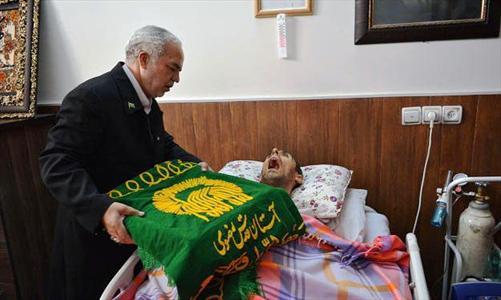 تبرک شهید زنده لرستانی به پرچم متبرک امام رضا(ع) +عکس